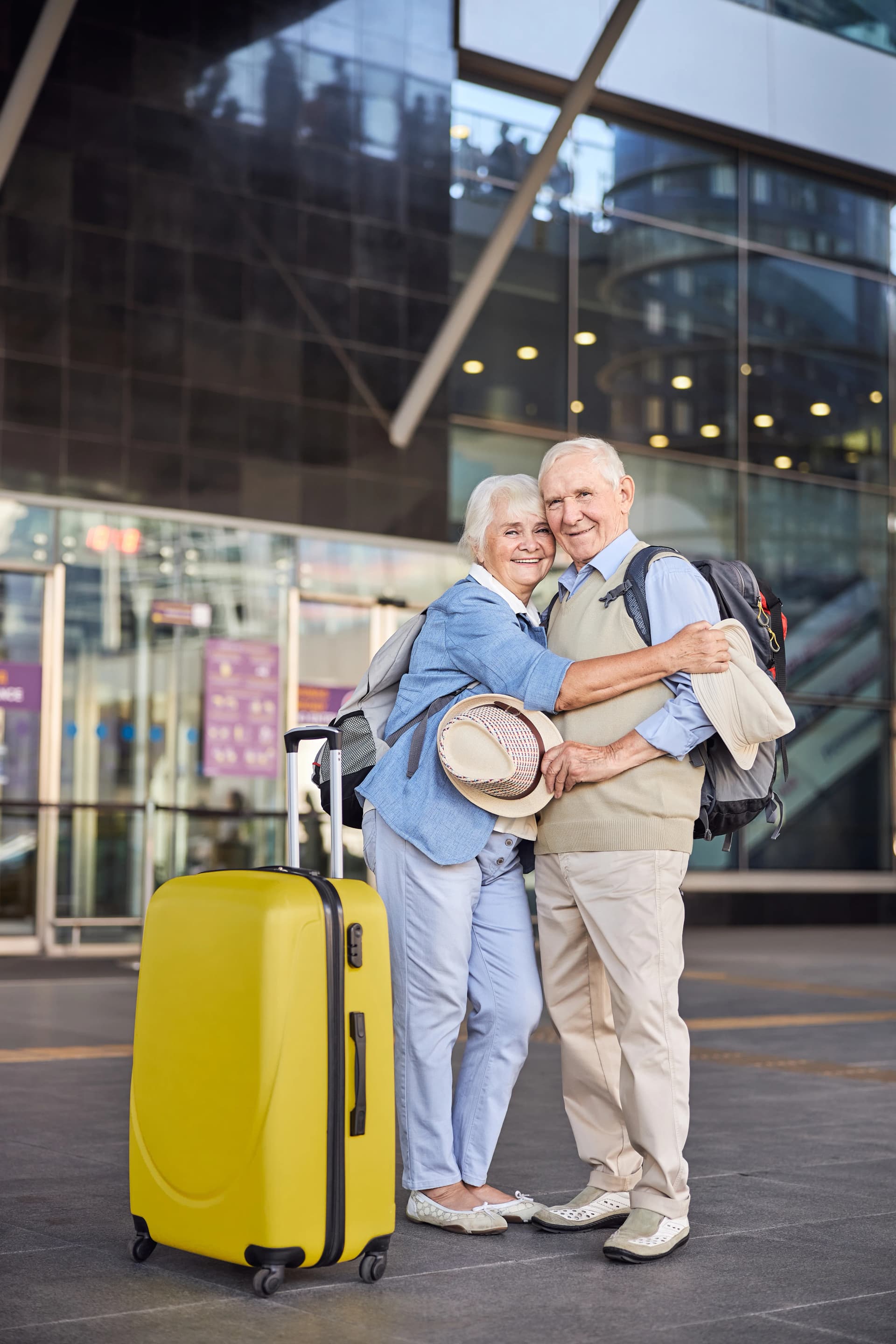 Couple de voyageurs seniors devant un aéroport